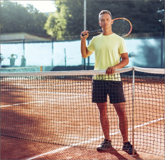 young-man-teenager-with-tennis-racket-standing-near-net-clay-court